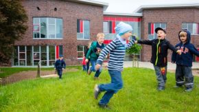 Kinder spielen auf dem Rasen