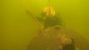 Taucher am Meeresboden mit Seilen an einem Munitionskörper