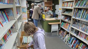 Drei Kinder lesen Bücher in der Leseecke der Flensburger Stadtbücherei