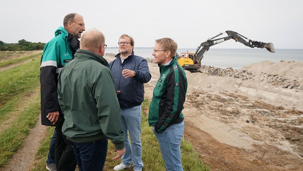 Vier Männer stehen im Kreis und unterhalten sich. Im Hintergrund steht ein Bagger. (Quelle: Staatskanzlei) Vier Männer stehen im Kreis und unterhalten sich. Im Hintergrund steht ein Bagger.