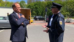 Europaminister Claussen spricht mit einem Polizisten.