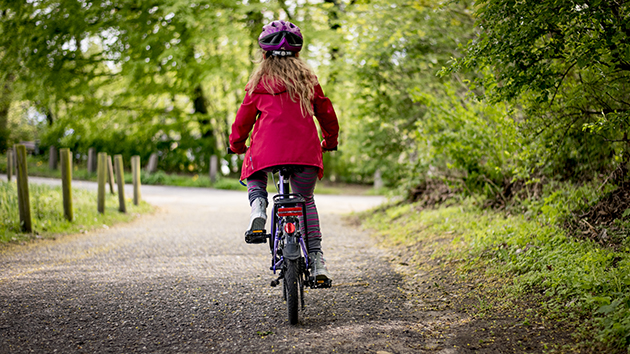 Ein Kind fährt auf einem Weg mit dem Fahrrad.