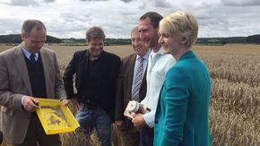 Fünf Personen stehen in einem Feld