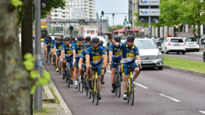 Mehrere Fahrradfahrer:innen. Auf ihren Trikots steht "Team Grenzland 2020".