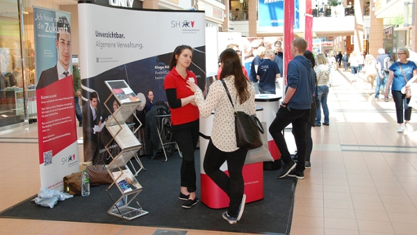 Menschen unterhalten sich an einem Infostand