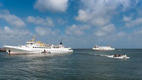 Zwei Börteboote transportieren Menschen von der Fähre zur Insel Helgoland.