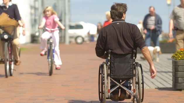 Ein Rollstuhlfahrer in einer Fußgängerzone