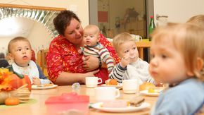 Kleine Kinder sitzen gemeinsam an einem Tisch.