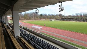 Ein Stadion mit grüner Rasenfläche und Laufbahn.