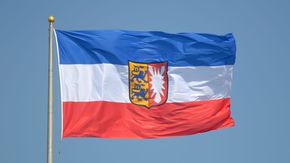 Die Schleswig-Holstein-Flagge weht im Wind