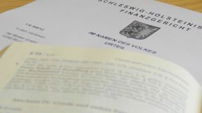 Urteil des Schleswig-Holsteinischen Finanzgerichts, im Vordergrund verschwommen ein Gesetzestext (Quelle: Finanzgericht) Urteil des Schleswig-Holsteinischen Finanzgerichts, im Vordergrund verschwommen ein Gesetzestext