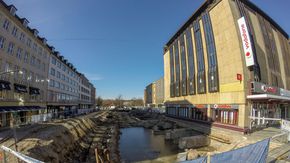 Eine Baustelle in einer Häuserschlucht, die zum Teil mit Wasser gefüllt ist