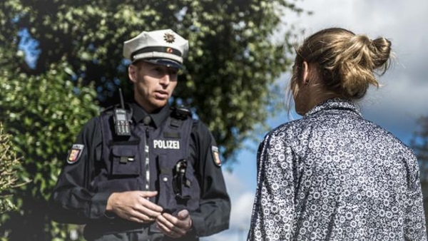 Ein Polizist im Gespräch mit einer weiblichen Person