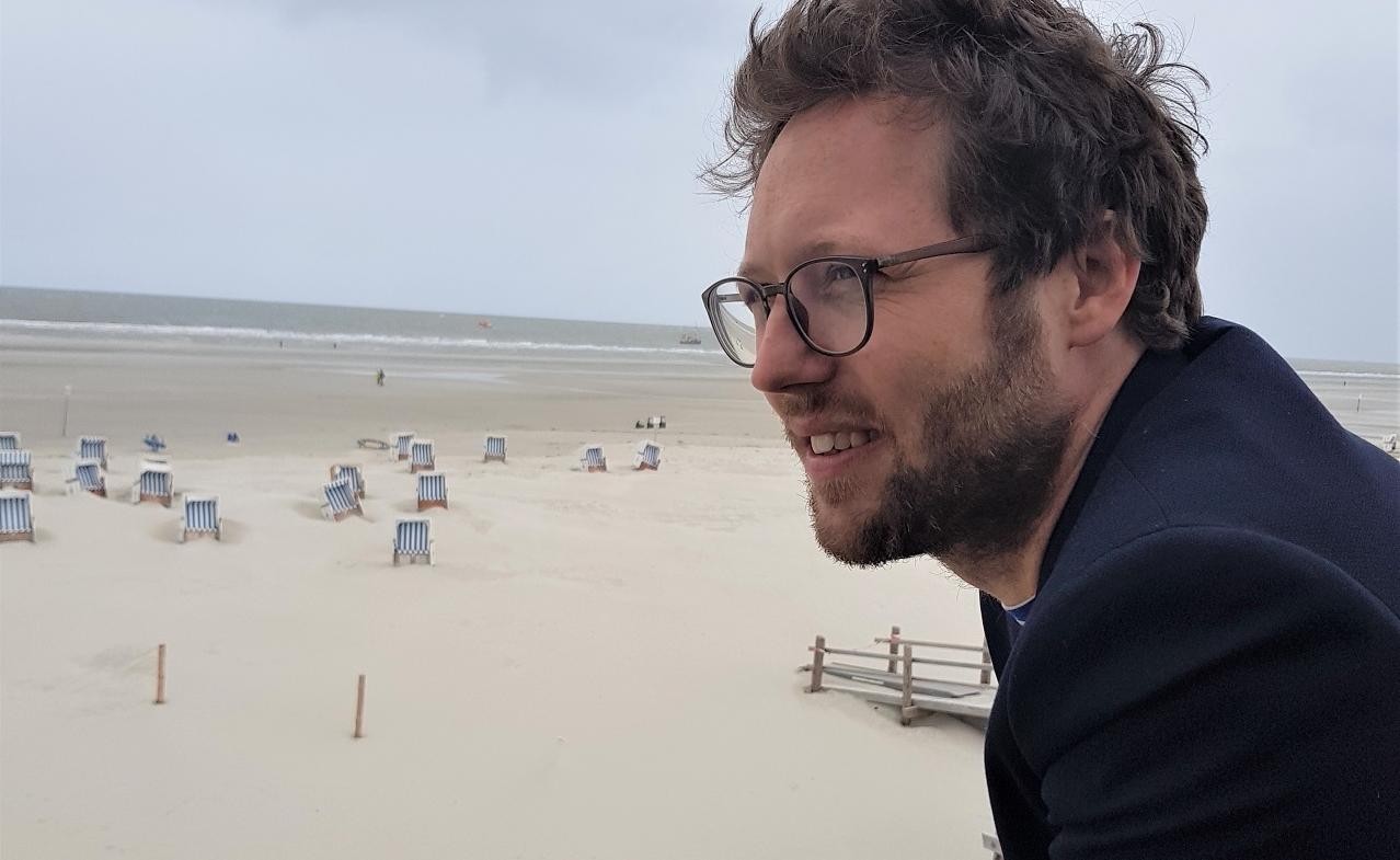 Ein Mann betrachtet den Strand von St. Peter Ording.