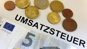 Münzen, Banknote und Schriftzug Umsatzsteuer