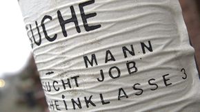 Wellig aufgeklebter Zettel "Mann sucht Job".